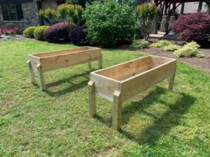 Raised garden planter shown in beautifully landscaped yard.