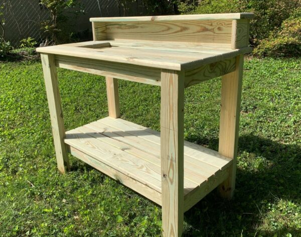 Potting table with slatted lower shelf and raised supply shelf.